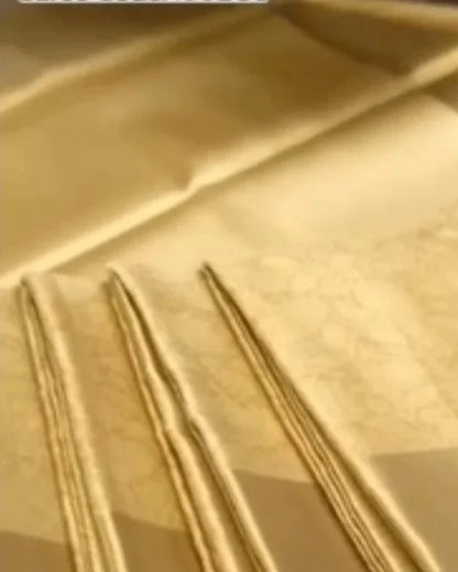 A close-up of a light beige or cream-colored fabric with a subtle woven pattern and three folded sections showing the texture and drape.